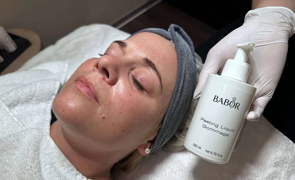 Der Kundin wird ein liquides Peeling aufgetragen.